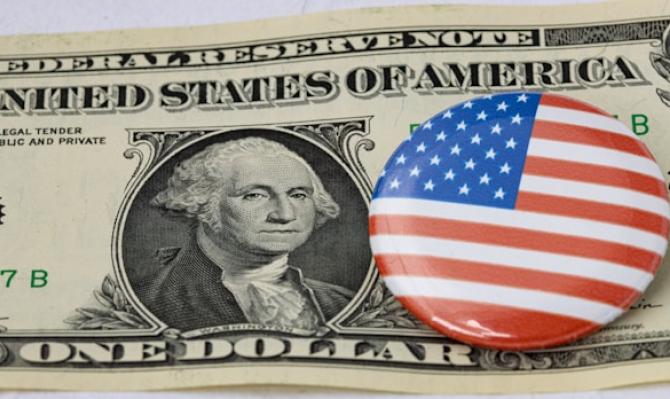 Pin con la bandera de EE. UU. sobre un billete de dólar. Photo by Maerk Studzinski on Unsplash