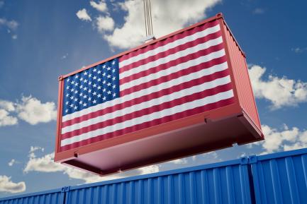 Contendor de mercancías con la bandera de Estados Unidos izado por una grua