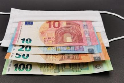 Billetes de 10, 20, 50 y 100 euros sobre una mascarilla. Photo by Nedret Binici on Unsplash