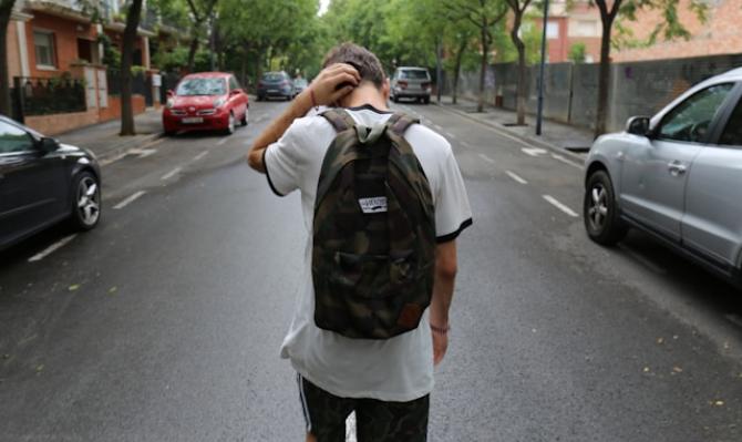 Joven de espaldas caminando por la calle. Photo by Jesús Rodríguez on Unsplash