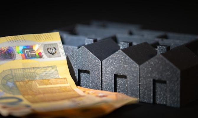 Billete y casas. Photo by Jakub Zerdzicki on Unsplash