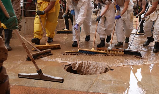 Grup de veïns desaiguant un carrer d'un municipi valencià. SGA Photo