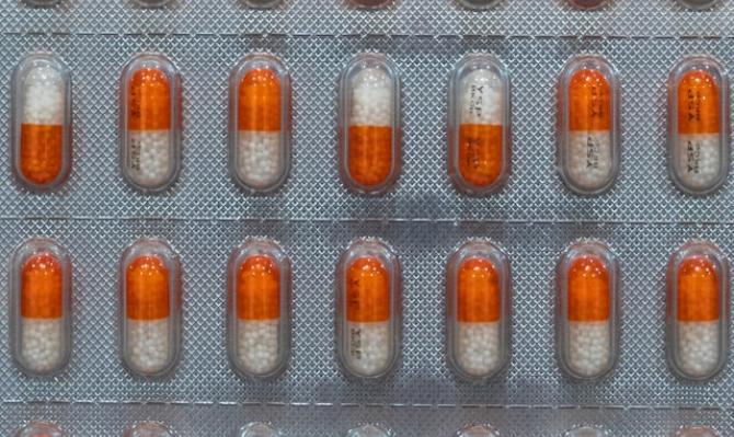 Blíster farmacéutico con pastillas naranjas y blancas. Photo by Harrison Chang on Unsplash