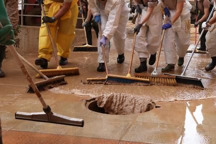 Grup de veïns desaiguant un carrer d'un municipi valencià. SGA Photo