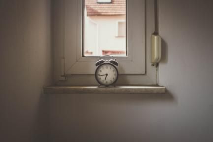 Reloj despertador sobre el alfeizar de una ventana. Photo by David von Diemar on Unsplash