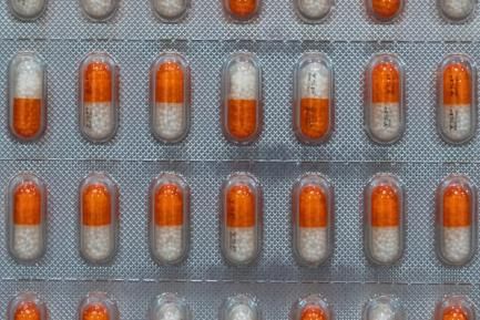 Blíster farmacéutico con pastillas naranjas y blancas. Photo by Harrison Chang on Unsplash