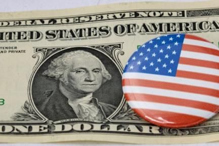 Pin con la bandera de EE. UU. sobre un billete de dólar. Photo by Maerk Studzinski on Unsplash