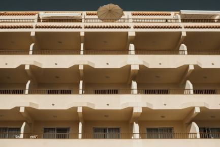 Foto de una fachada de apartamentos con terraza. Photo by Thomas Chizzali on Unsplash