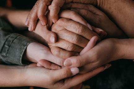 Manos enlazadas de personas de distintas edades