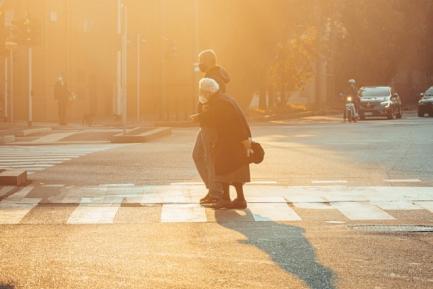 Hombre cruzando a señora mayor en un paso de cebra. Photo by Mikita Yo on Unsplash