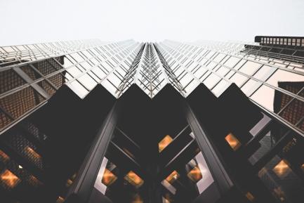 Plano contrapicado de un rascacielos de acero oscuro y vidrio. Photo by Lianhao on Unsplash