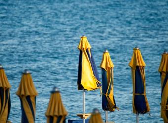 Sombrillas cerradas en una playa para ilustrar un artículo de análisis económico